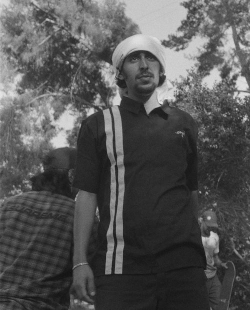 Gal Ankri wearing a shirt on his head with tall trees in the background