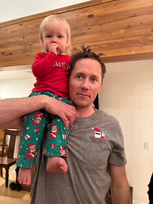 Gregory Bokenkamp holding his son on his shoulder with a proper goggle tan