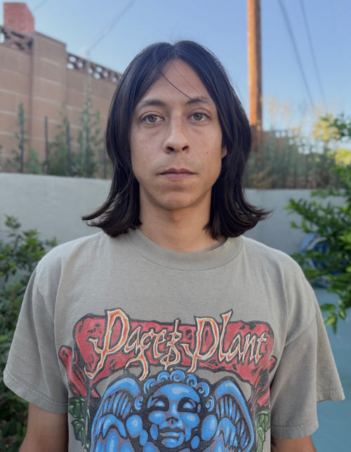 Erro Perez wearing a 'Page & Plant' t-shirt with a colorful graphic design