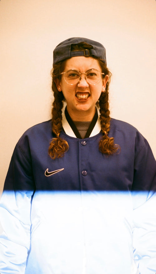 Victoria Ruesga wearing a blue jacket with a Nike logo against a plain background