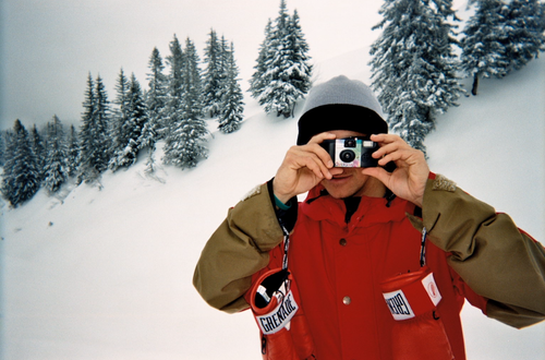 Shayne Pospisil in a snowy landscape taking a photo with a camera
