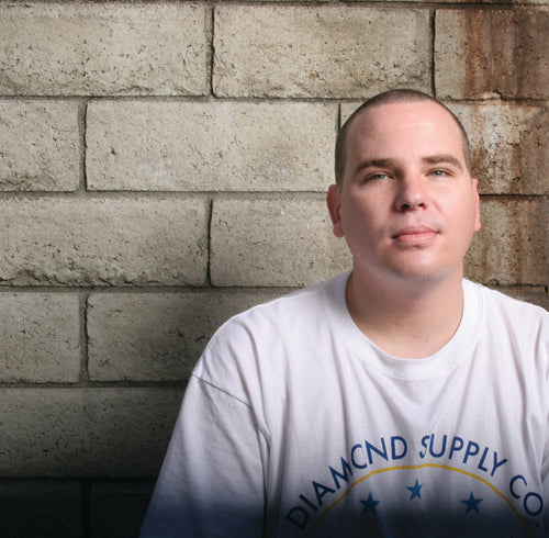 Weston Correa wearing a white t-shirt against a concrete brick wall